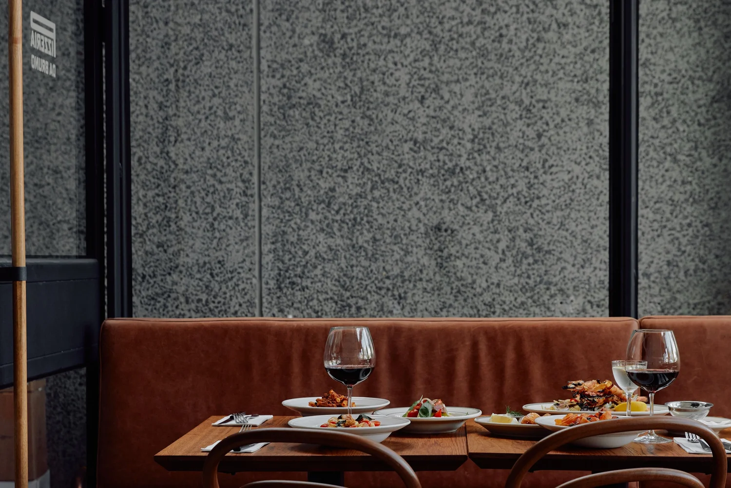 Antipasti and wine on the leather banquette at Pizzeria Da Bruno
