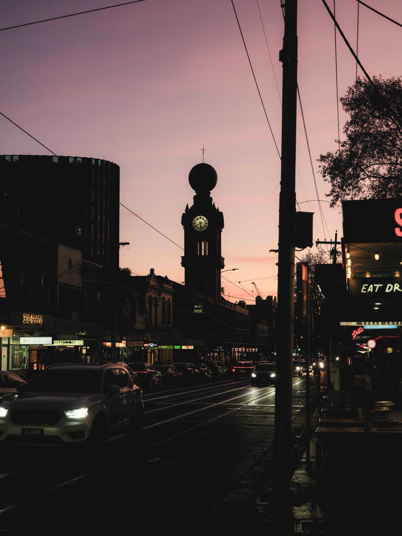 The Dimmeys clock tower on Swan Street, Richmond, silhouetted against a pink dusk sky